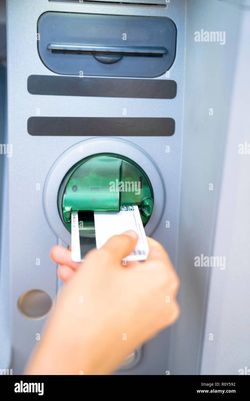 Le mani tirando il denaro da ATM Foto Stock