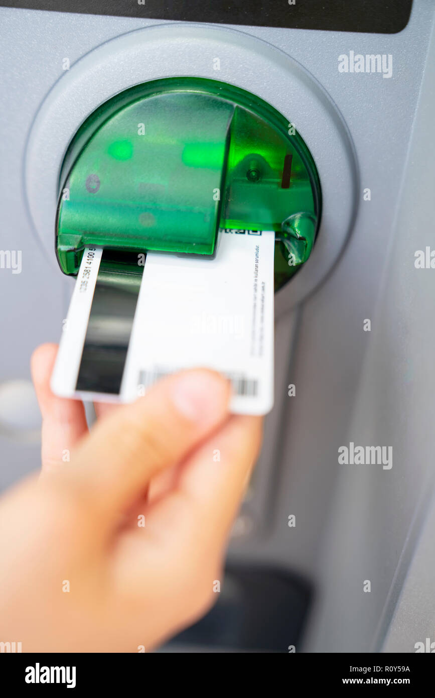 Le mani tirando il denaro da ATM Foto Stock