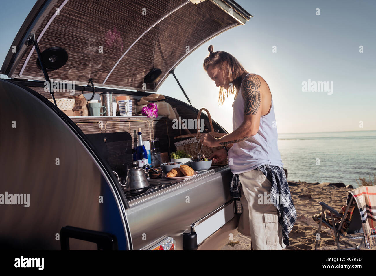 Cura Uomo prepara la colazione per la sua donna dopo la notte in casa mobile Foto Stock