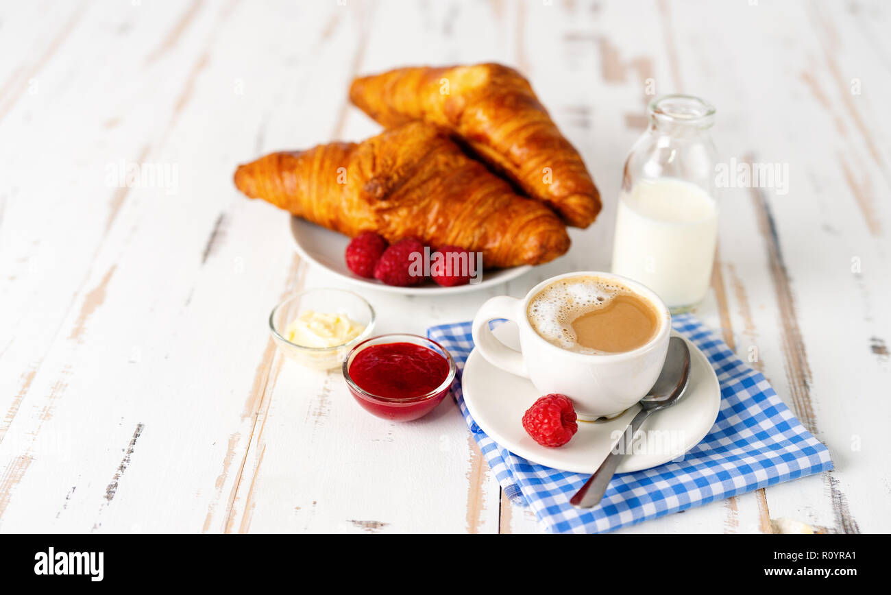 Tazza di caffè e due cornetti per la prima colazione sul tavolo bianco Foto Stock