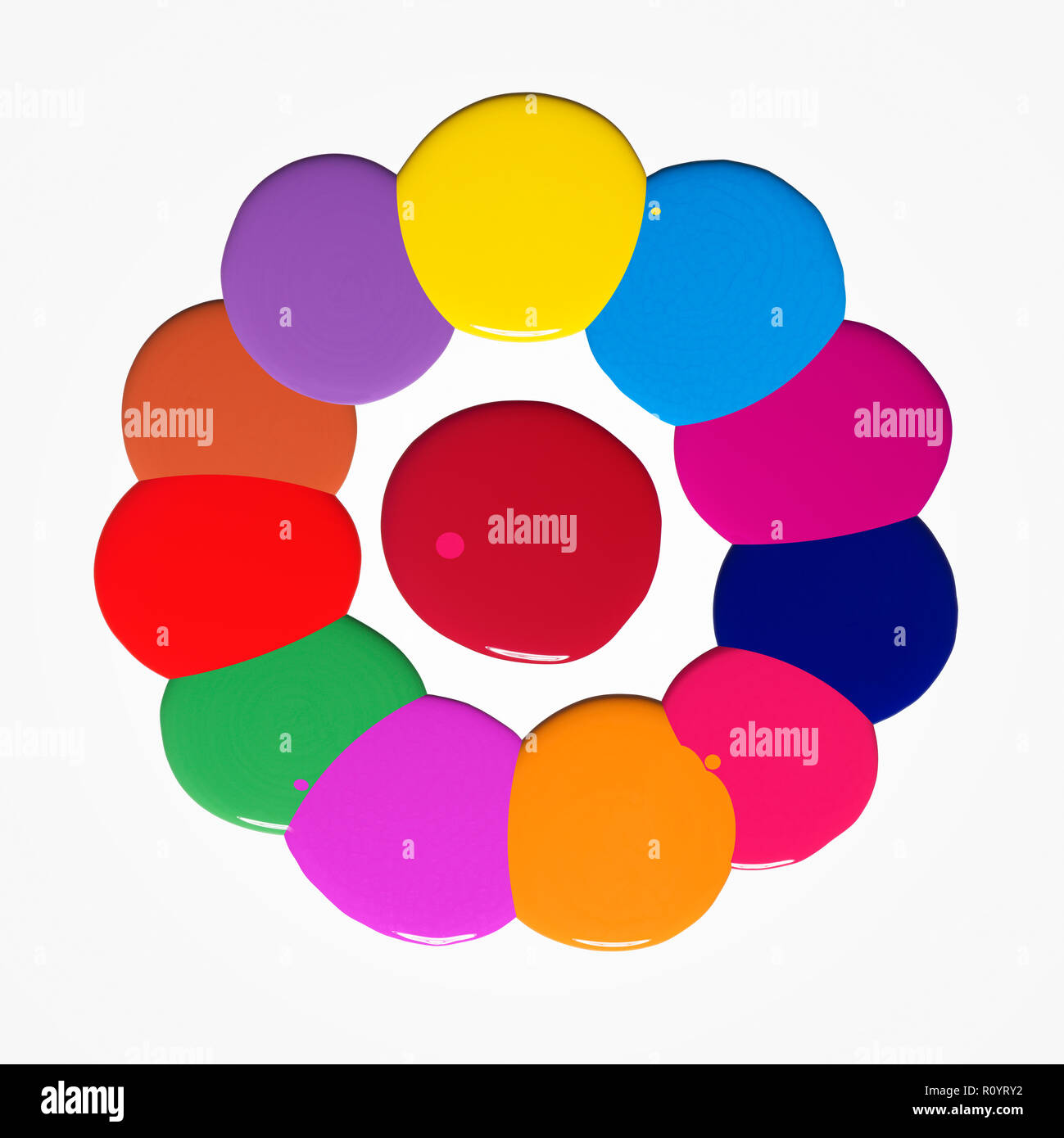 Blob multicolore di lucido smalto per unghie su sfondo bianco formando un cerchio Foto Stock
