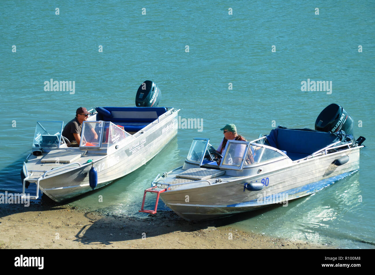 Novosibirsk 07-31-2018. Gli uomini siedono in barche a motore sulla spiaggia. Foto Stock