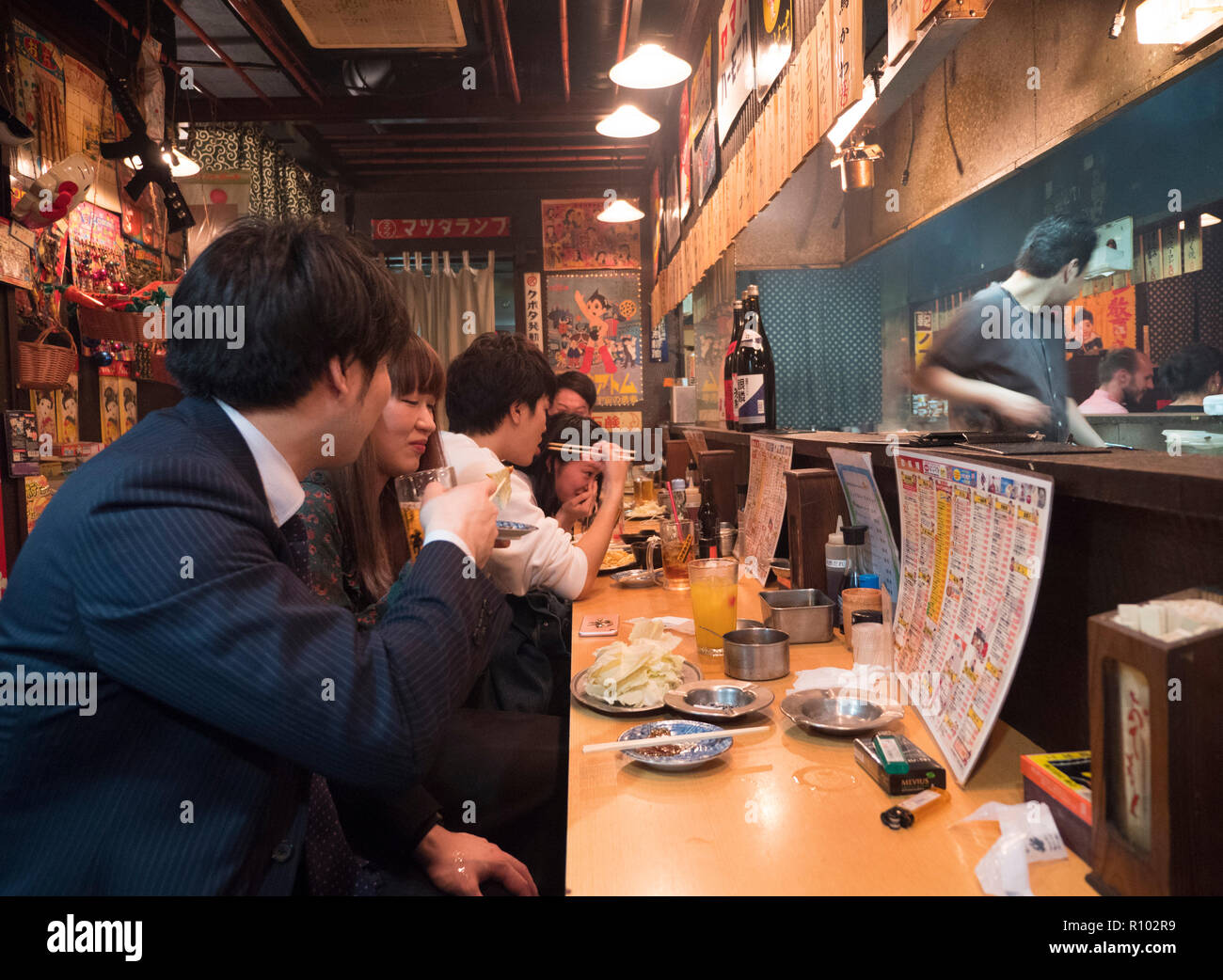 Alle persone di mangiare in un ristorante di Izakaya in zona di Shibuya di Tokyo, Giappone. Foto Stock