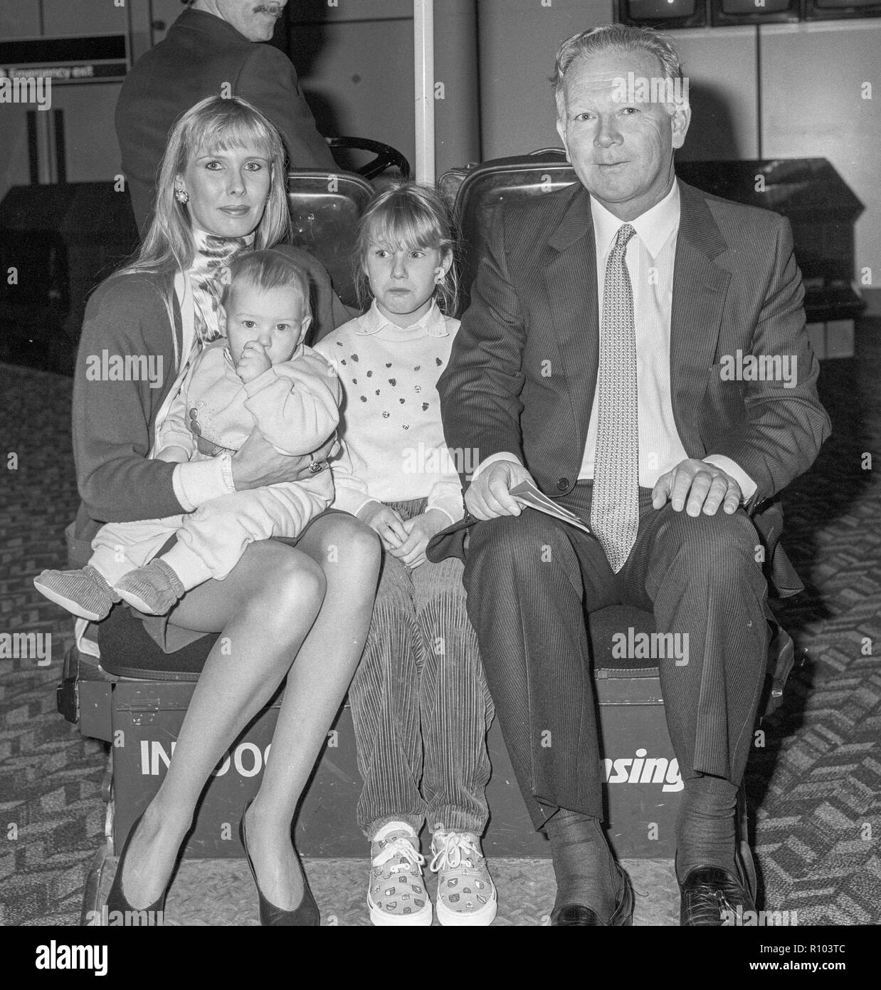 Proprietario delle corse ippiche e allevatore Robert Sangster con mia moglie Susan Lilley e due bambini lasciando Heathrow nel febbraio 1988 Foto Stock