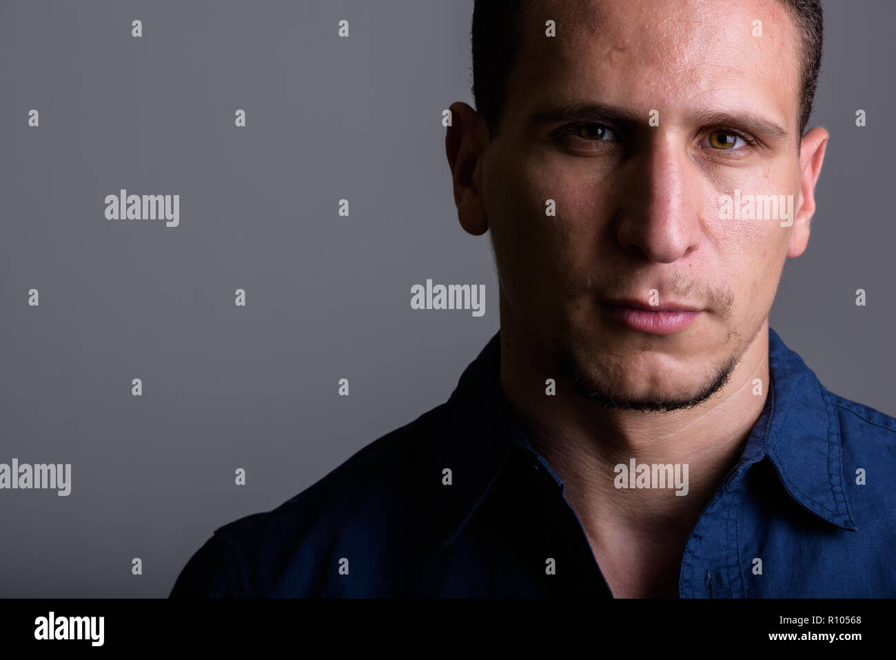 Close up di giovani persiano muscolare uomo contro uno sfondo grigio Foto Stock