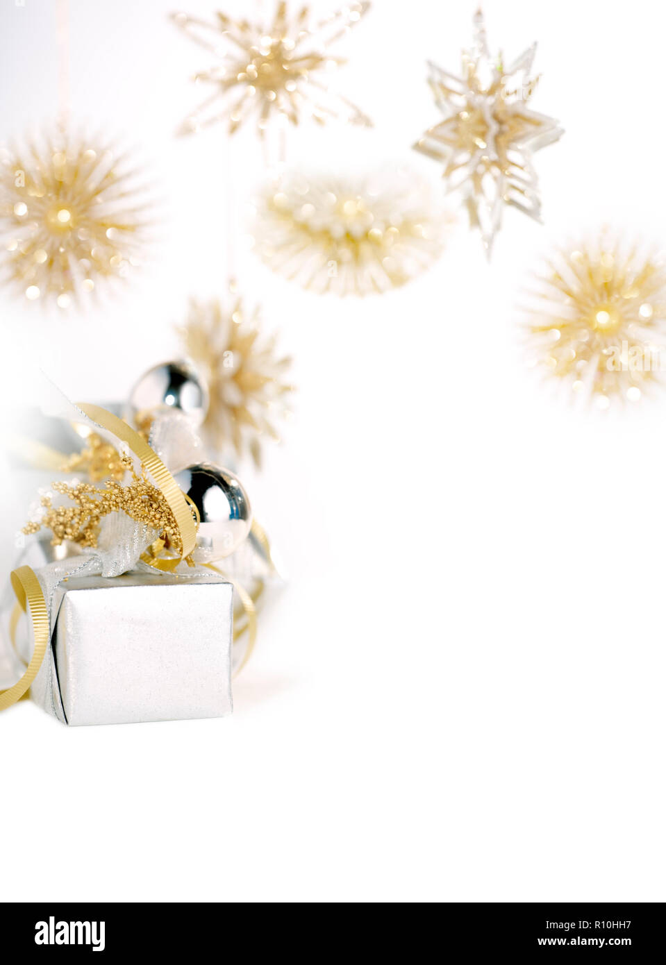 Piccolo regalo di Natale decorato con baubles, Oro Snowflake decorazioni appeso a sfondo bianco Foto Stock