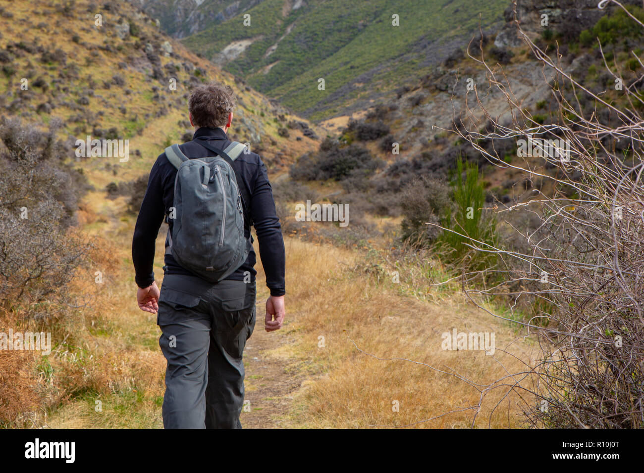 Un uomo gode di uno stile di vita sano trekking ed escursioni in collina per esercizio e avventura Foto Stock