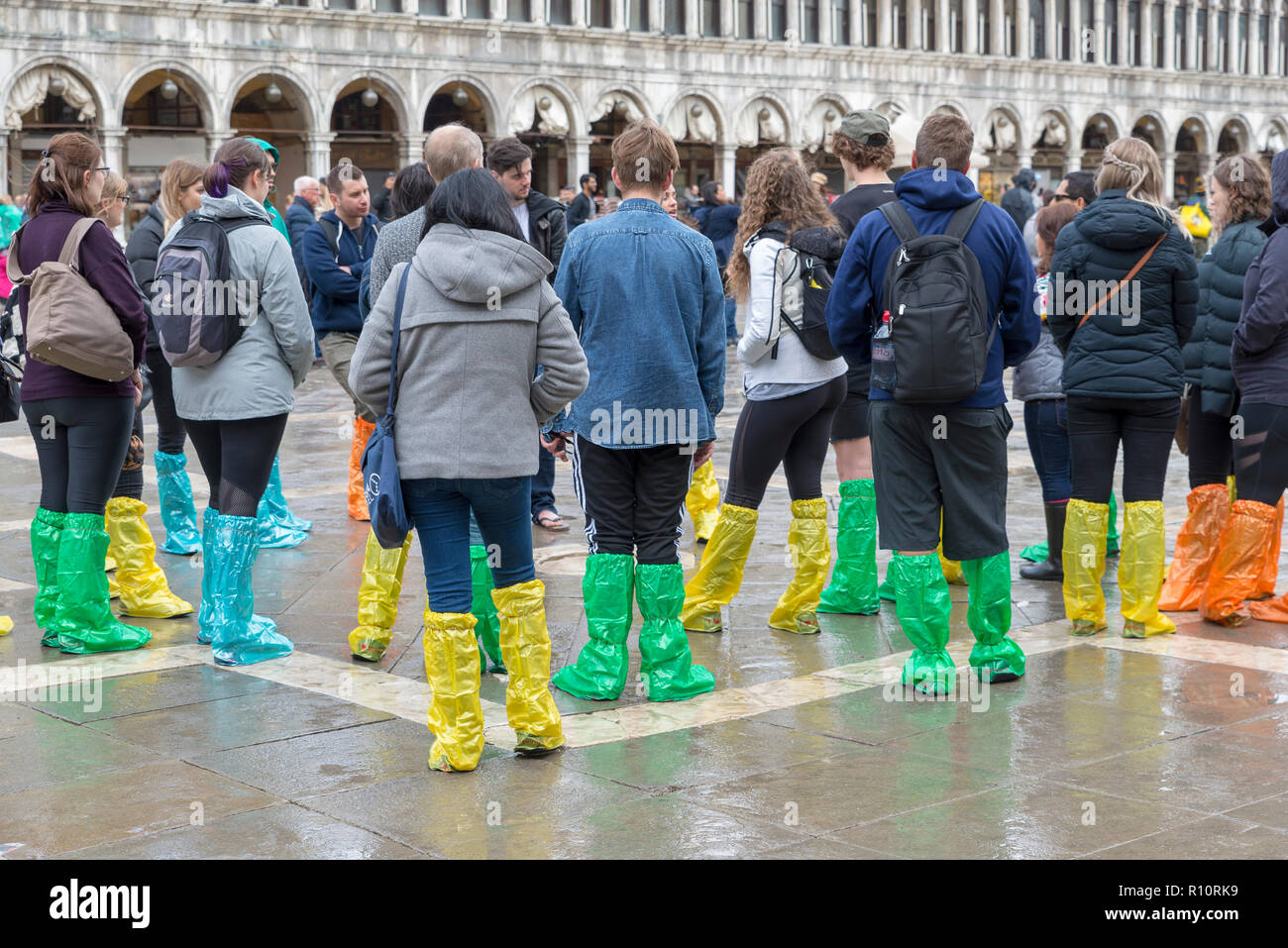 Venezia, Italia- Ottobre 30, 2018: Turisti in Piazza San Marco di indossare stivali  di gomma attendono l'acqua alta (acqua alta Foto stock - Alamy