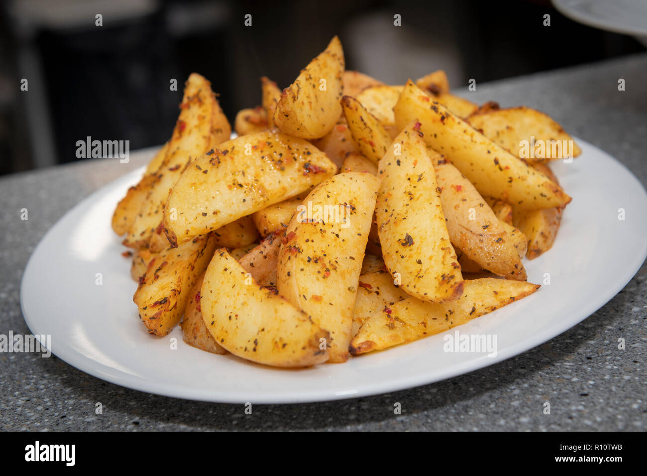 Una ciotola di Spicchi di patate , patate arrosto cunei Foto Stock