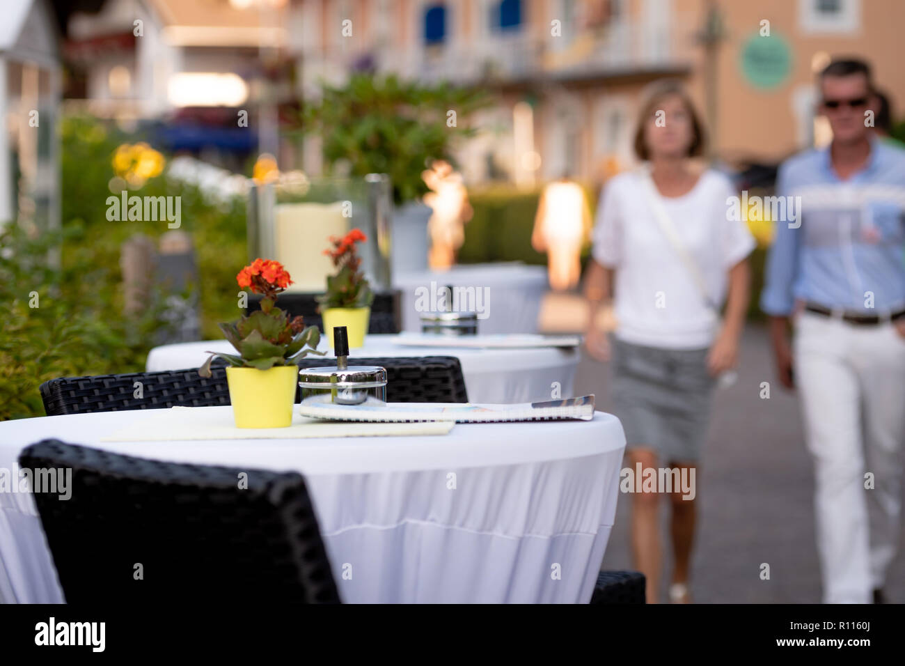 KLAGENFURF, Carinzia, Austria - 07 agosto 2018: Cafe tabelle su strada. In fondo è una strada con sagome umane. Foto Stock