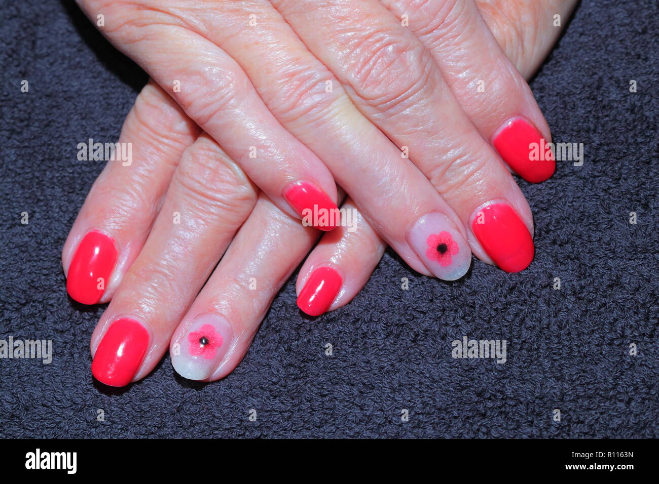 Dipinto di unghie con un ricordo di papavero applicato. Foto Stock