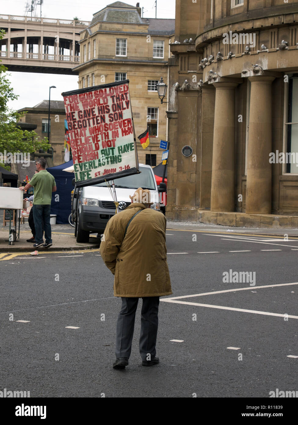 Il vecchio uomo che porta sulla targhetta, con dipinti a mano i messaggi di Dio. Camminando per le strade di Newcastle, Inghilterra. Foto Stock