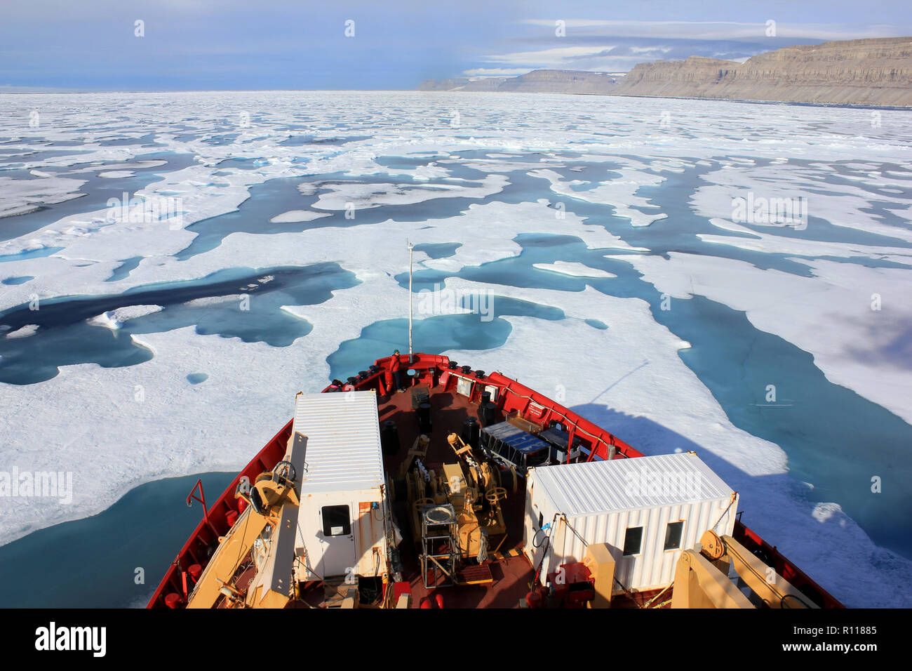 Scienziato presso la prua della CCGS Amundsen come ella irrompe attraverso il ghiaccio in Lancaster Suono, Canada Artico Foto Stock