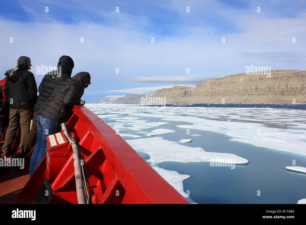 Gli scienziati a prua della CCGS Amundsen come ella irrompe attraverso il ghiaccio in Lancaster Suono, Canada Artico Foto Stock