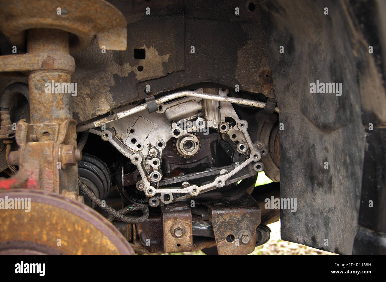 Motore, montaggio motore e rusty disco del freno su una rotta auto nel cortile Foto Stock