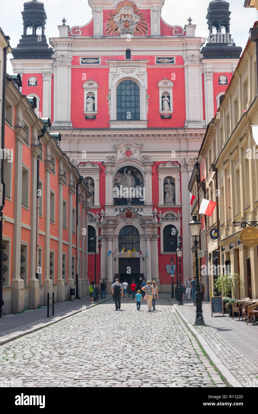 La città di Poznan street, vista di persone a Poznan Città Vecchia a piedi verso la facciata barocca di San Stanislao Chiesa Parrocchiale, Polonia. Foto Stock