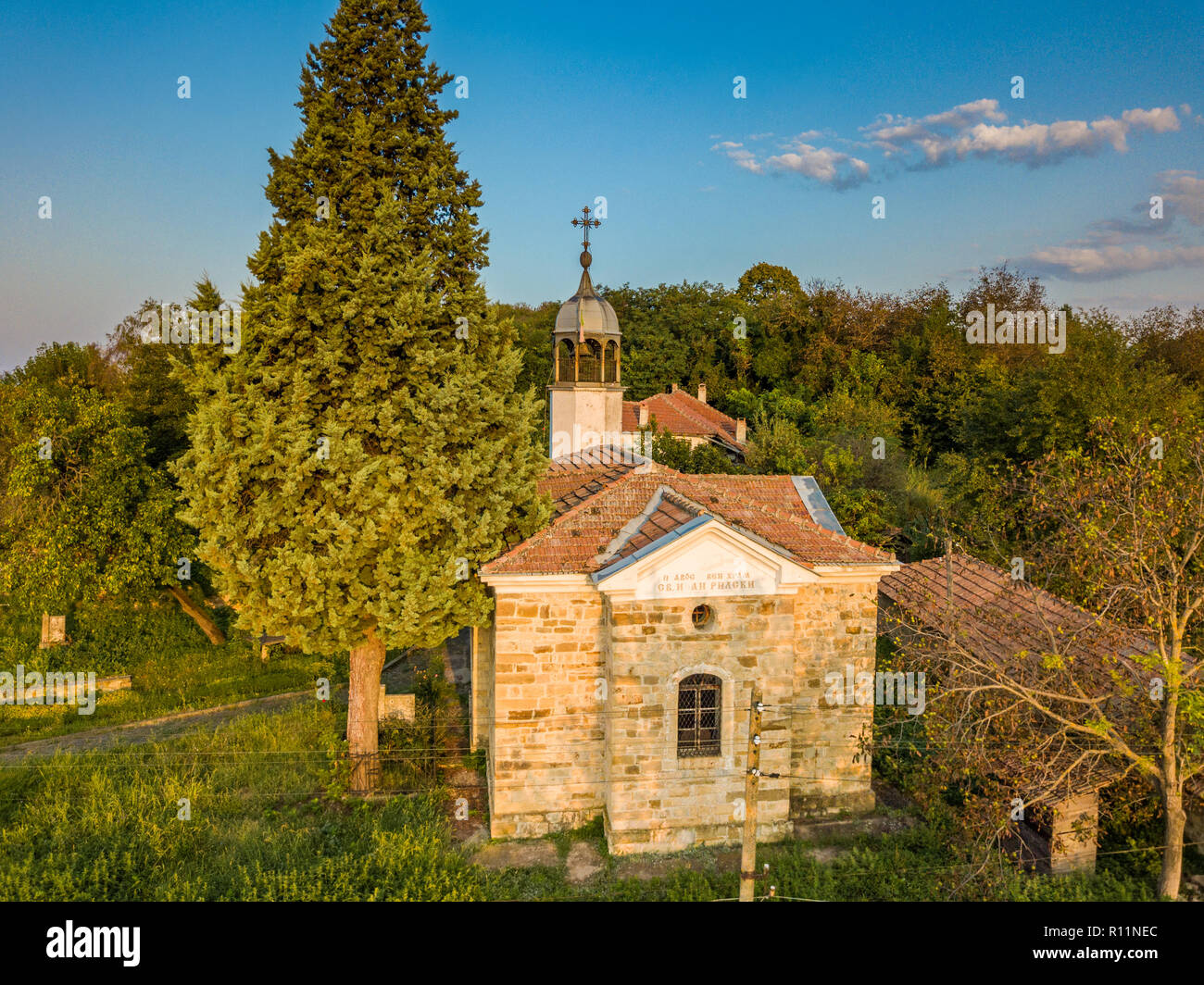 Riprese aeree di un piccolo cristiano ortodosso di villaggio nel nord della Bulgaria - La piccola chiesa, tipiche case - bellissima alba in una campagna rilassante Foto Stock