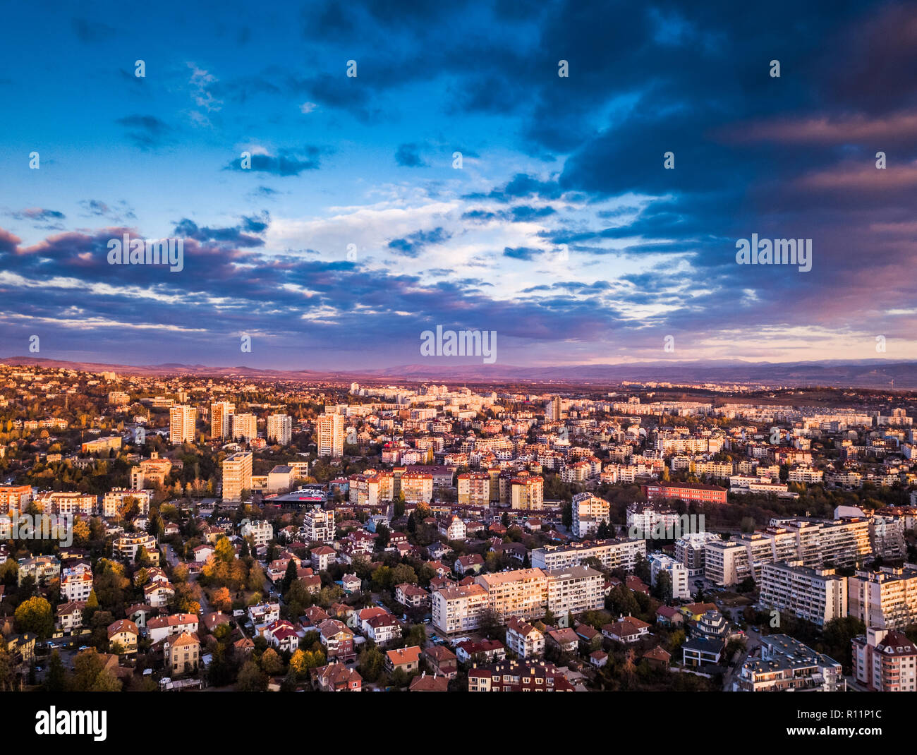 Bella drone shot sulla città di Sofia presso sunrise - sorprendenti immagini brillanti con colorati cieli, sfondo montano e tipico paesaggio urbano Foto Stock