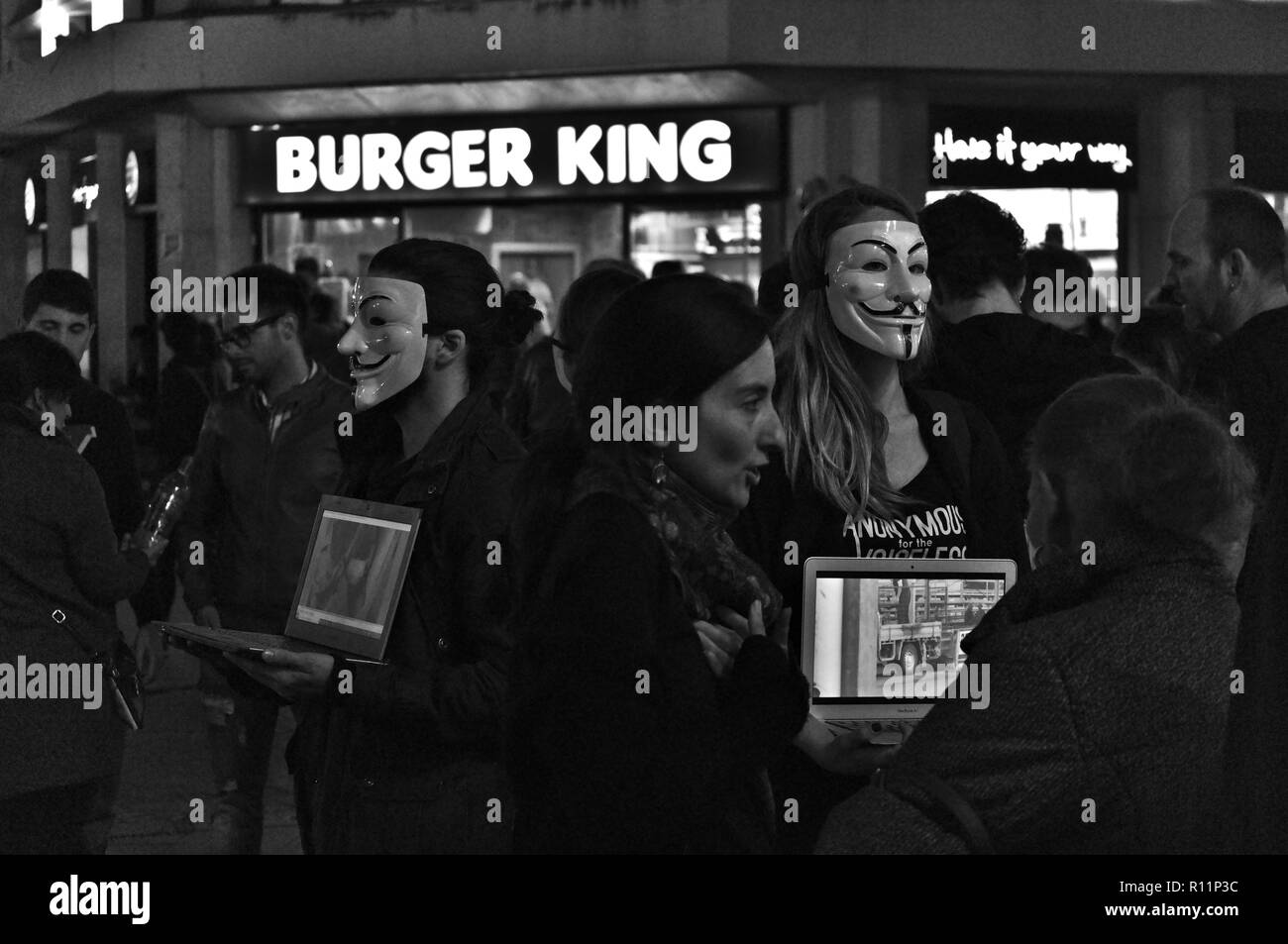 Anonimo attivisti protesta per difendere i diritti degli animali, nella parte anteriore di un Burger King ristorante a Siviglia, Spagna Foto Stock