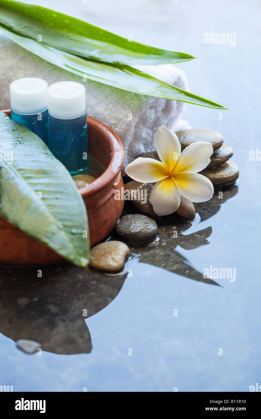 Spa oggetti e pietre per trattamenti di massaggio sullo sfondo con  bottiglie di olio Foto stock - Alamy