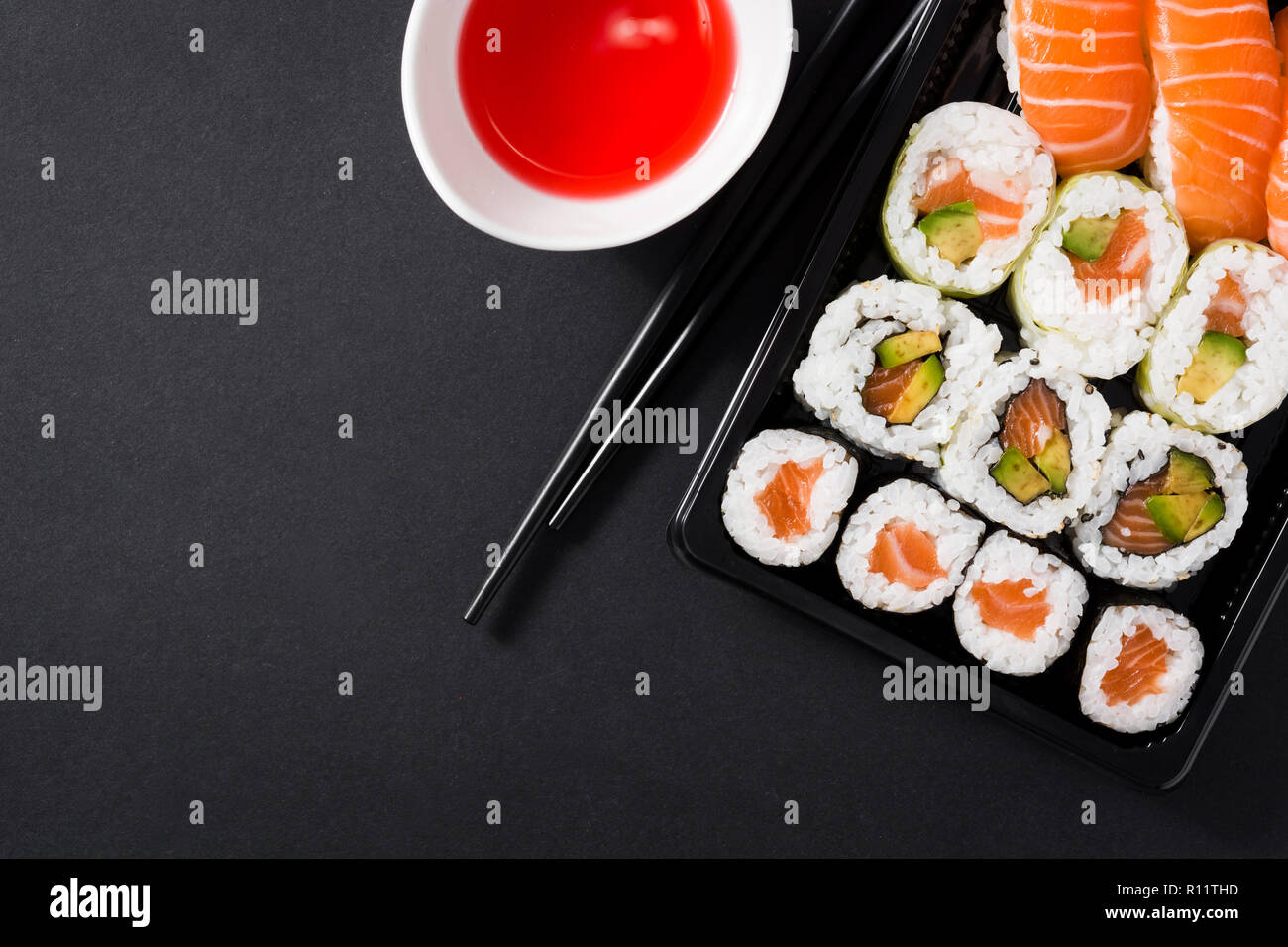 Maki e nigiri sushi set su sfondo nero. Vista dall'alto. Copyspace Foto Stock