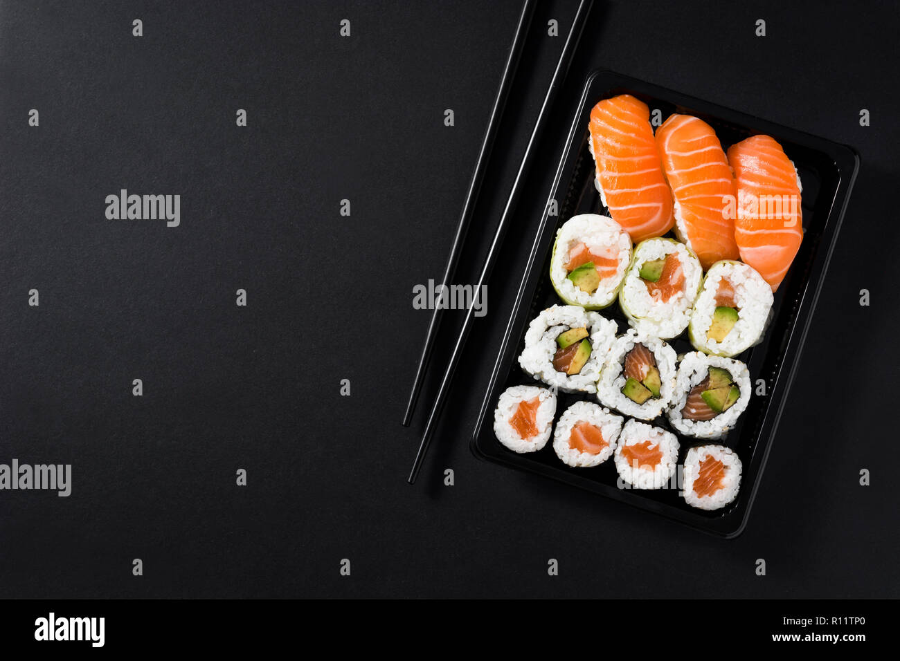 Maki e nigiri sushi set su sfondo nero. Vista dall'alto. Copyspace Foto Stock