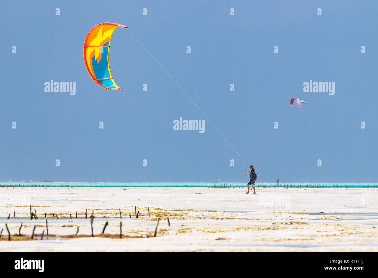 Kiteboarding vicino al villaggio di Jambiani. Zanzibar è uno dei luoghi migliori per il kitesurf vacanze. Calda acqua poco profonda e costante vento. Foto Stock