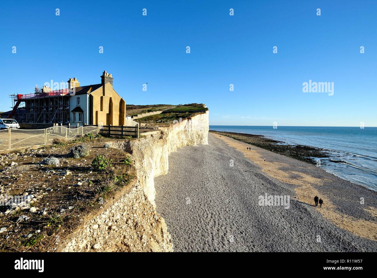 Old coastguard cottages sul bordo di chalk cliffs, mostrando erosione costiera a Birling Gap East Sussex England Regno Unito Foto Stock