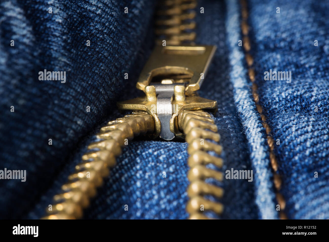Ottone decompressi zipper closeup sul jeans blu Foto Stock