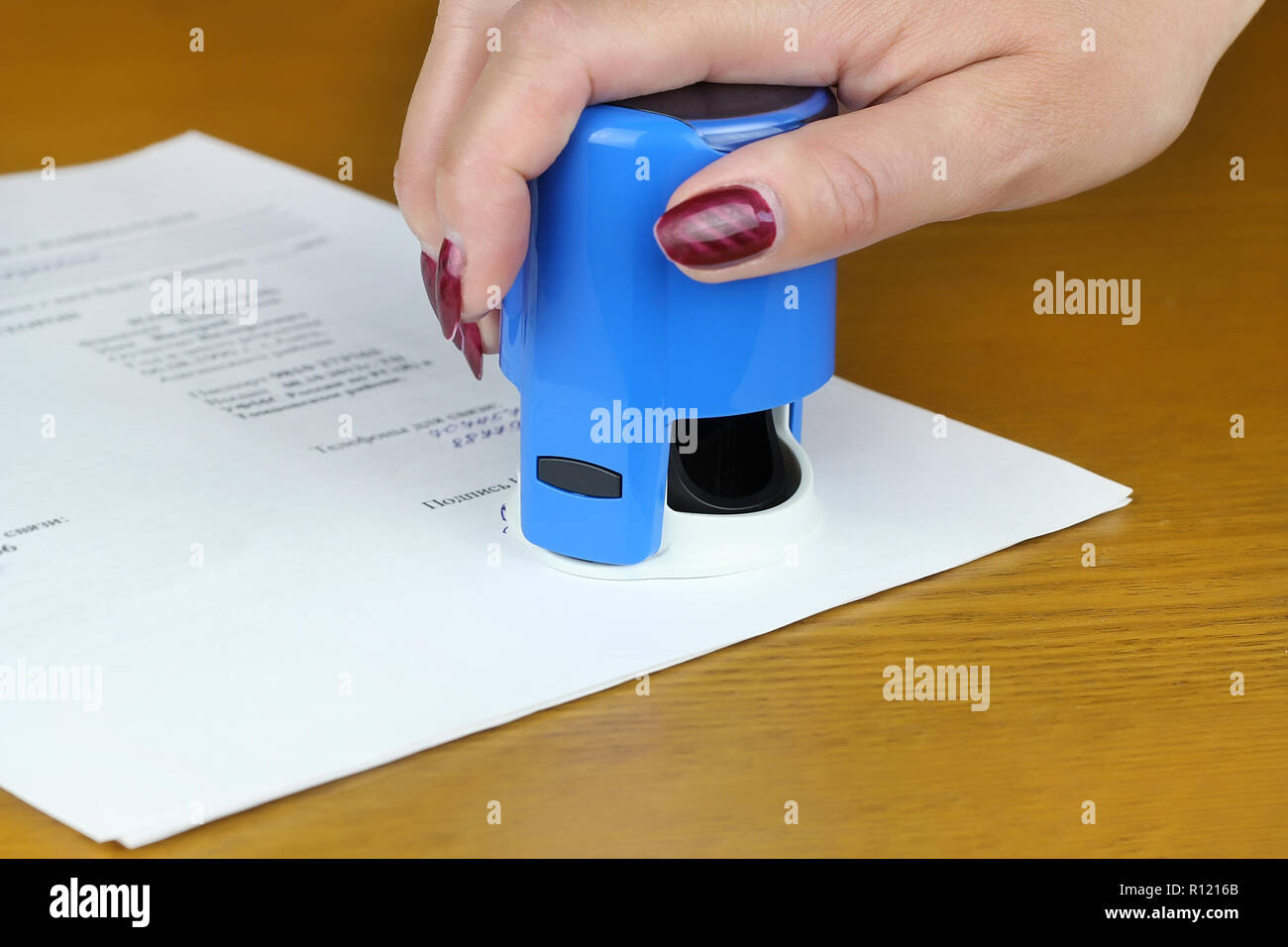 Donna blu di mettere il timbro sul documento close up Foto Stock