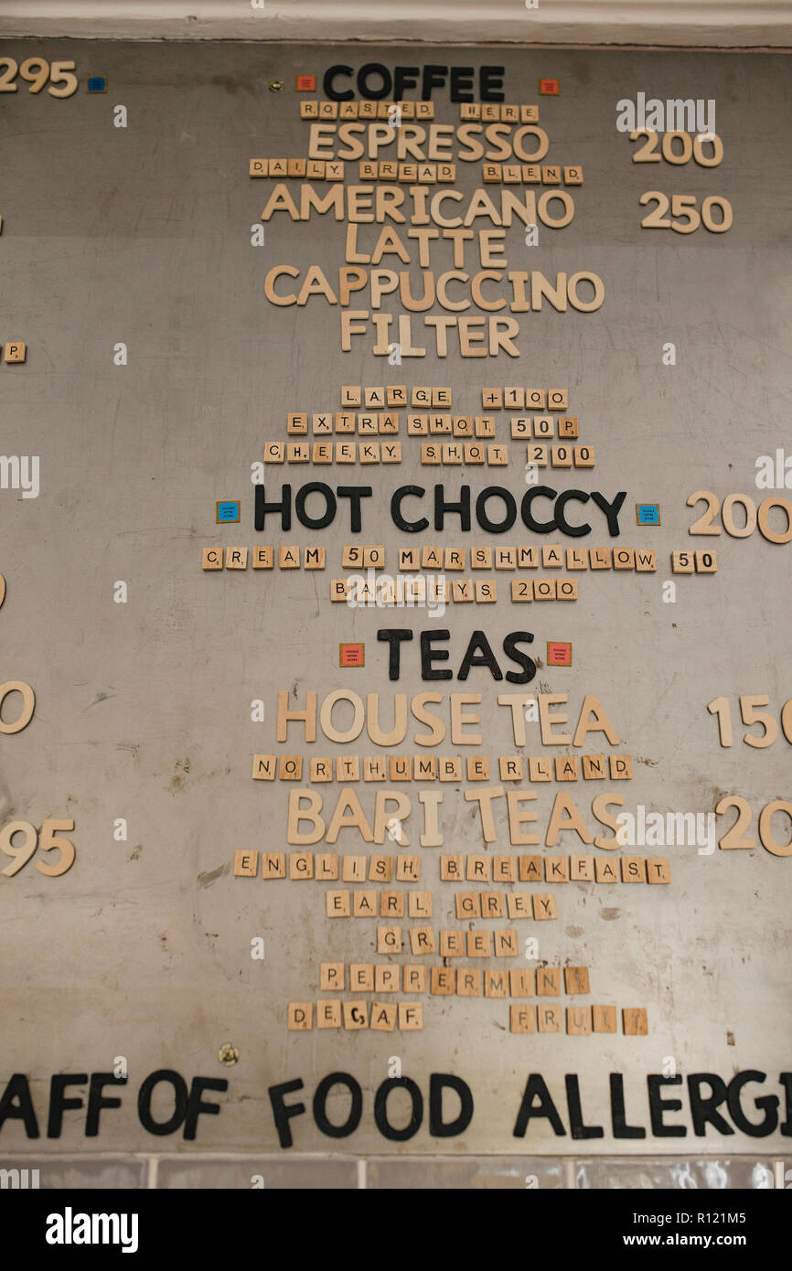 Basso angolo vista di una bevande calde menu sulla parete in una caffetteria. Essi hanno utilizzato poco piastrella lettere sulla parete a precisare le diverse voci del menu Foto Stock