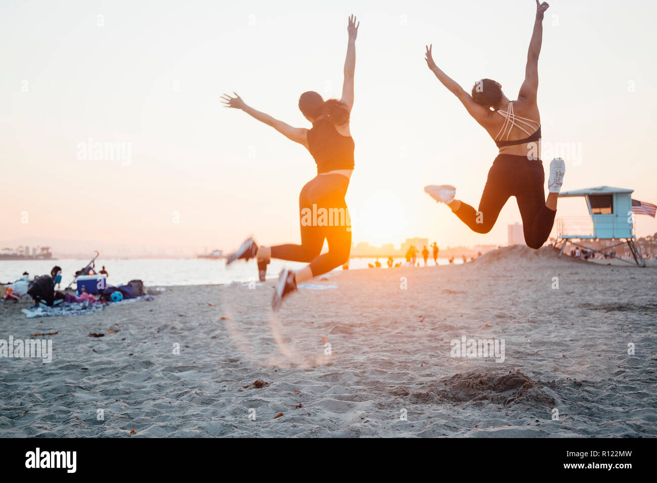 Gli amici di saltare sul Beach, Long Beach, California, US Foto Stock