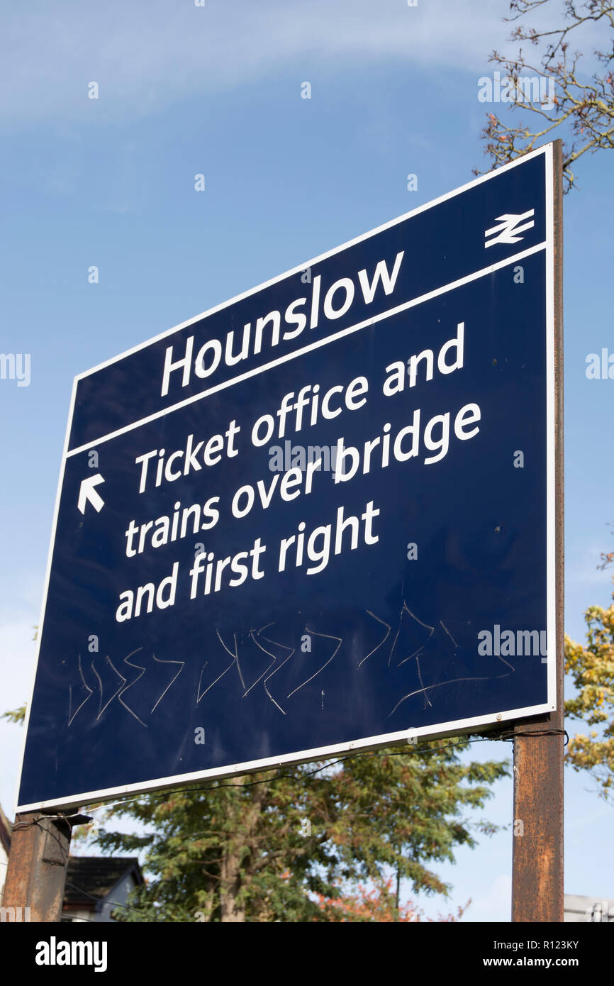 Segno dare indicazioni e che indica il percorso di hounslow stazione ferroviaria, Hounslow, Middlesex, Inghilterra Foto Stock