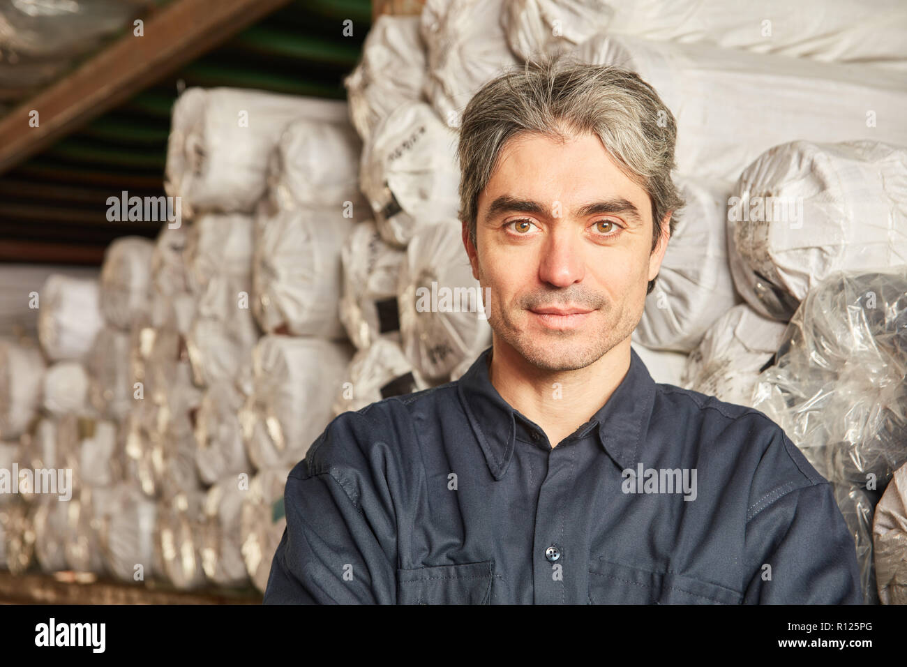 L'uomo come un lavoratore di magazzino o lo specialista magazzino nel tappeto magazzino di un magazzino Foto Stock