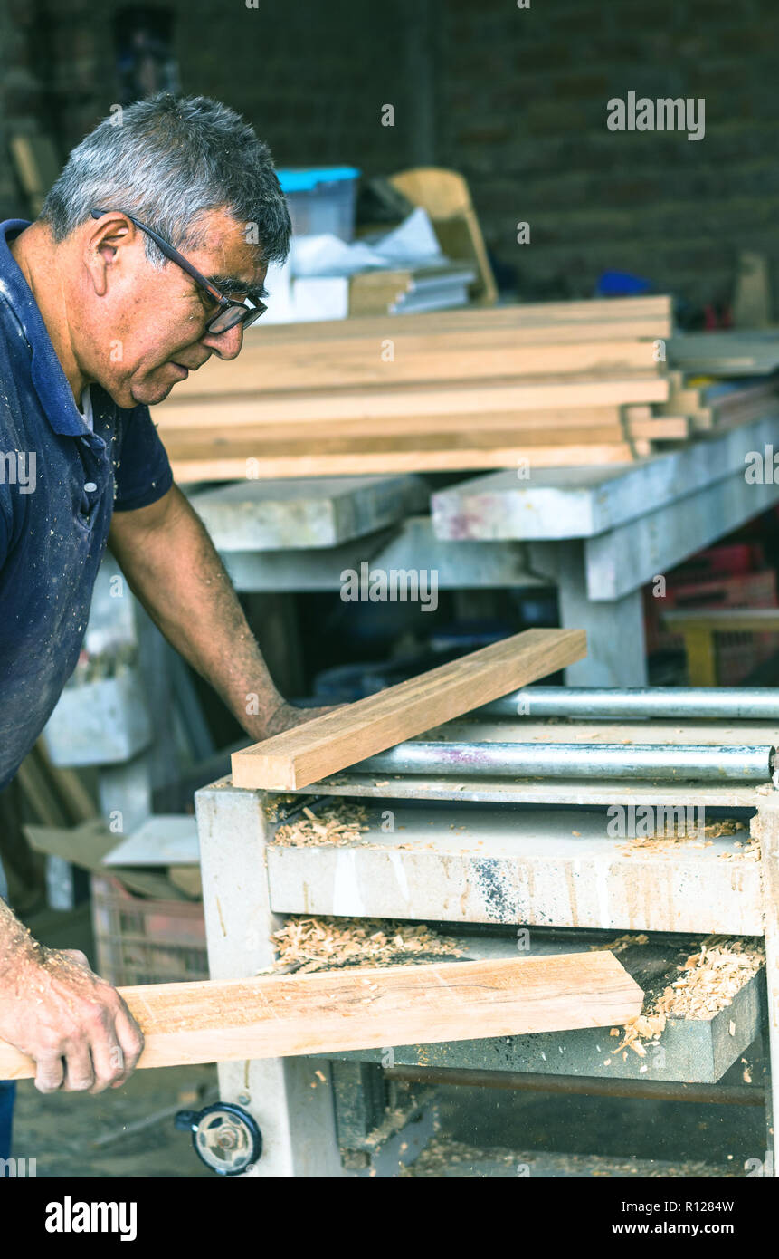 Carpenter utilizzando levigatrice a nastro. Carpenter la levigazione di un legno con levigatrice a nastro Foto Stock