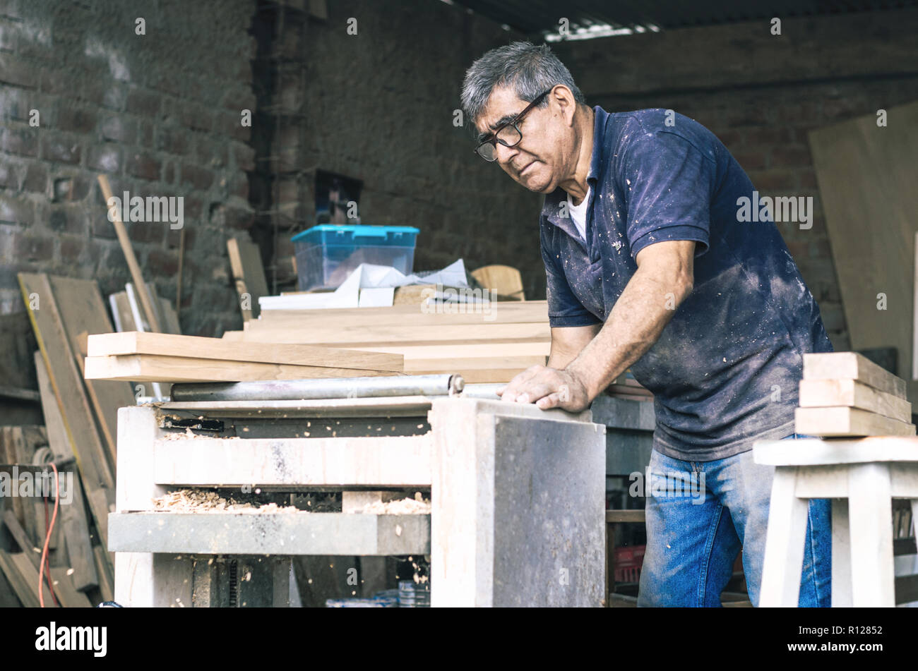 Carpenter utilizzando levigatrice a nastro. Carpenter la levigazione di un legno con levigatrice a nastro Foto Stock