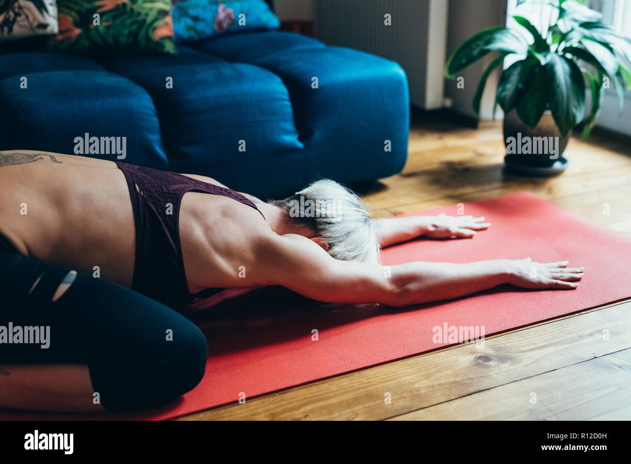 La donna a praticare yoga a casa Foto Stock