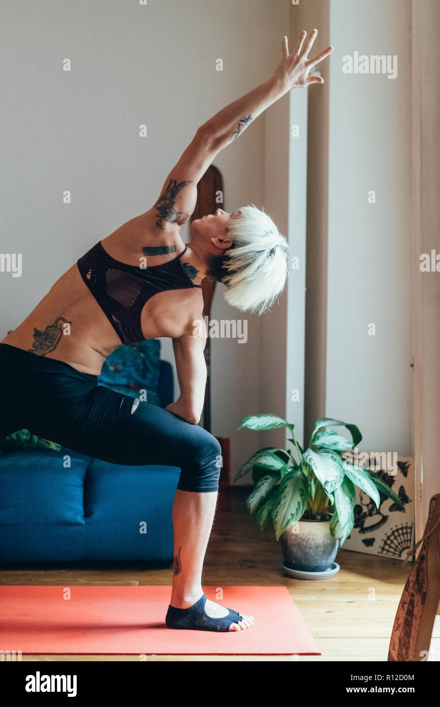 La donna a praticare yoga a casa Foto Stock