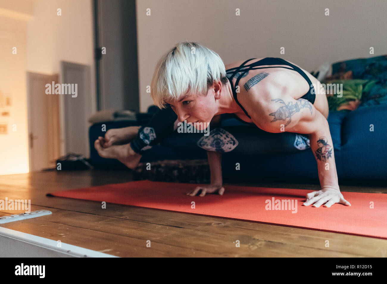 La donna a praticare yoga a casa Foto Stock