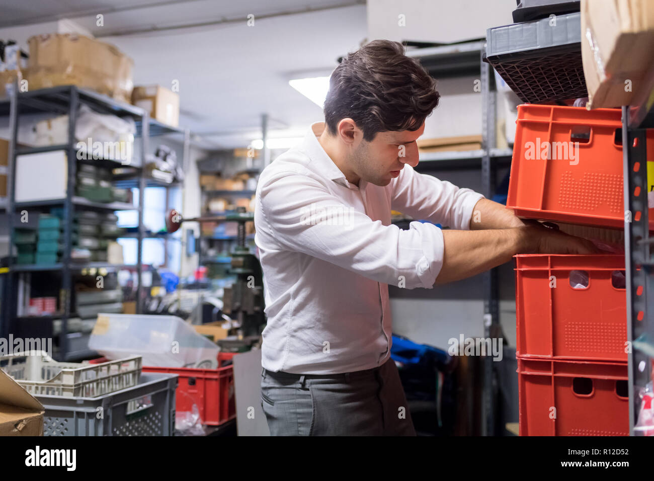 Uomo al lavoro su carte e piani in magazzino Foto Stock