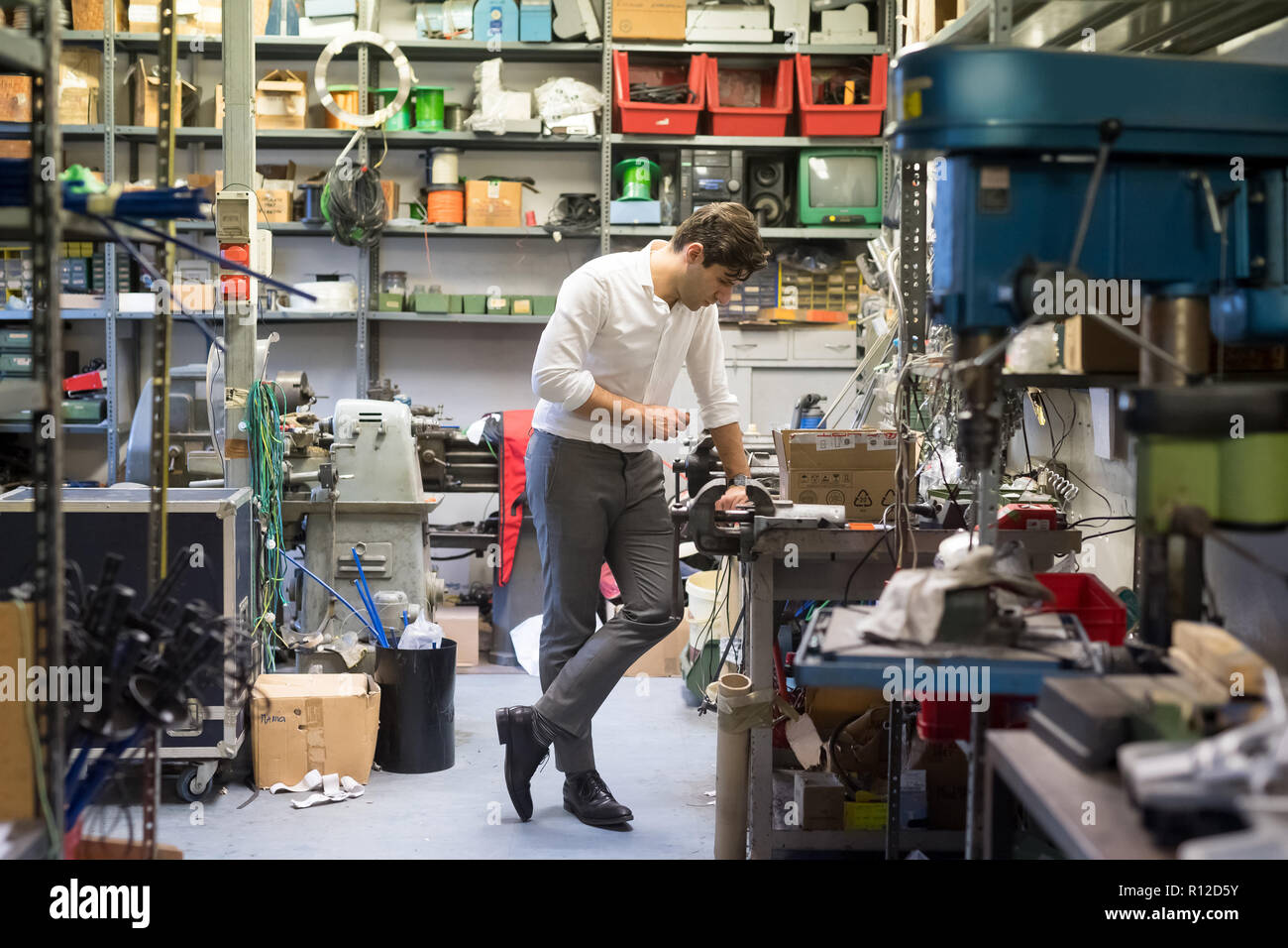Uomo che guarda alla postazione di lavoro in officina Foto Stock