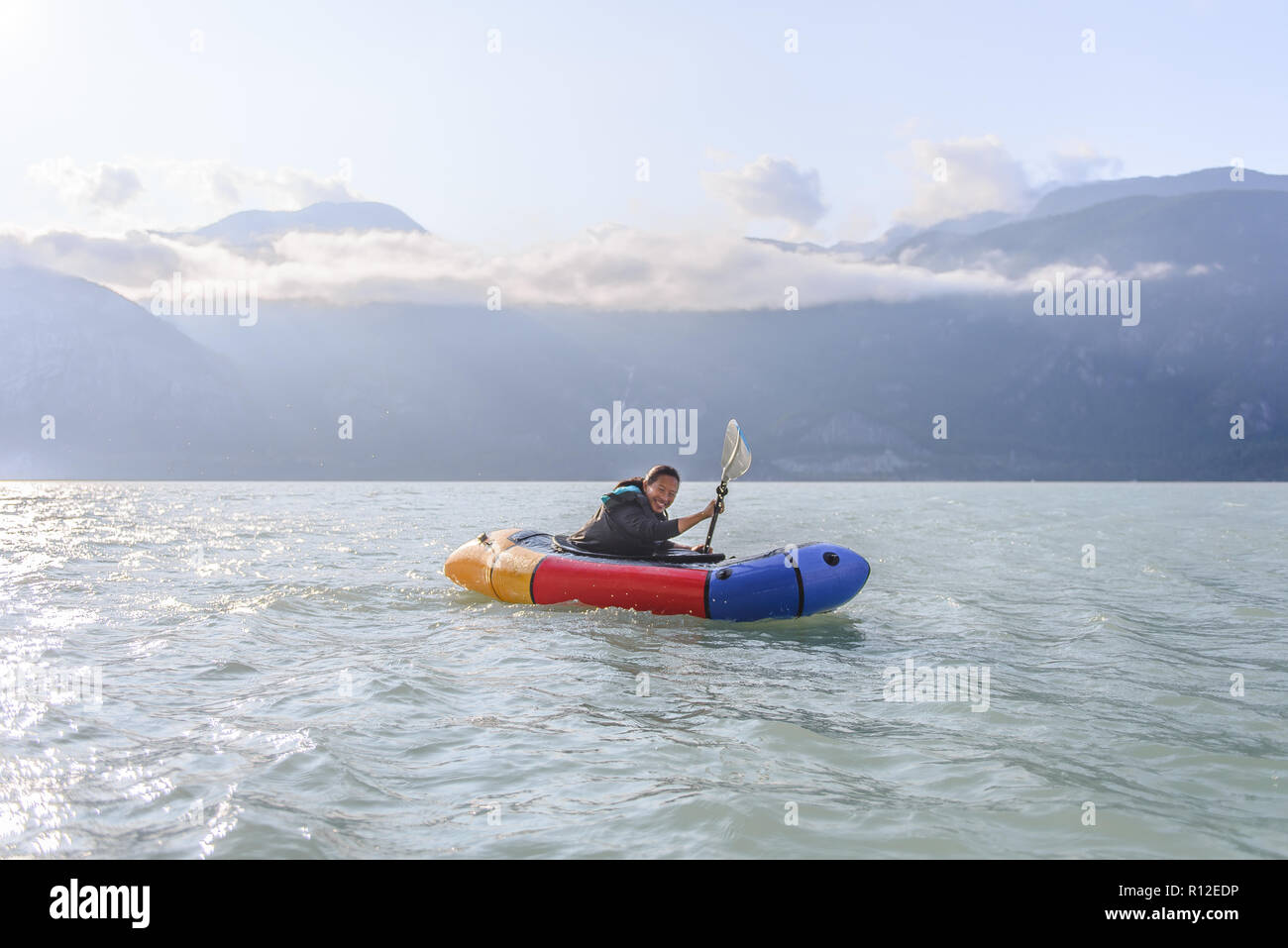 Donna packrafting, Howe Sound bay, Squamish, Canada Foto Stock