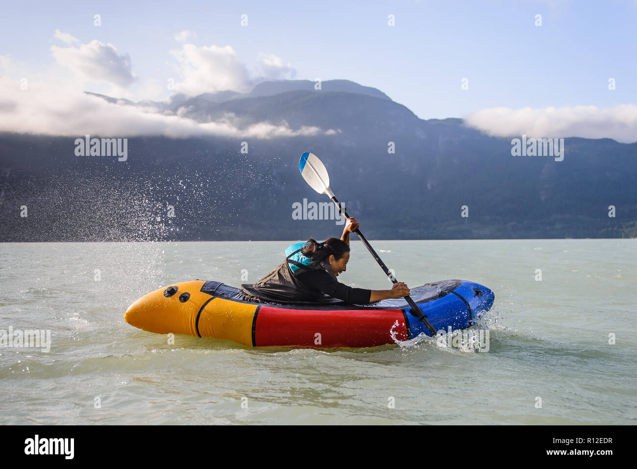 Donna packrafting, Howe Sound bay, Squamish, Canada Foto Stock
