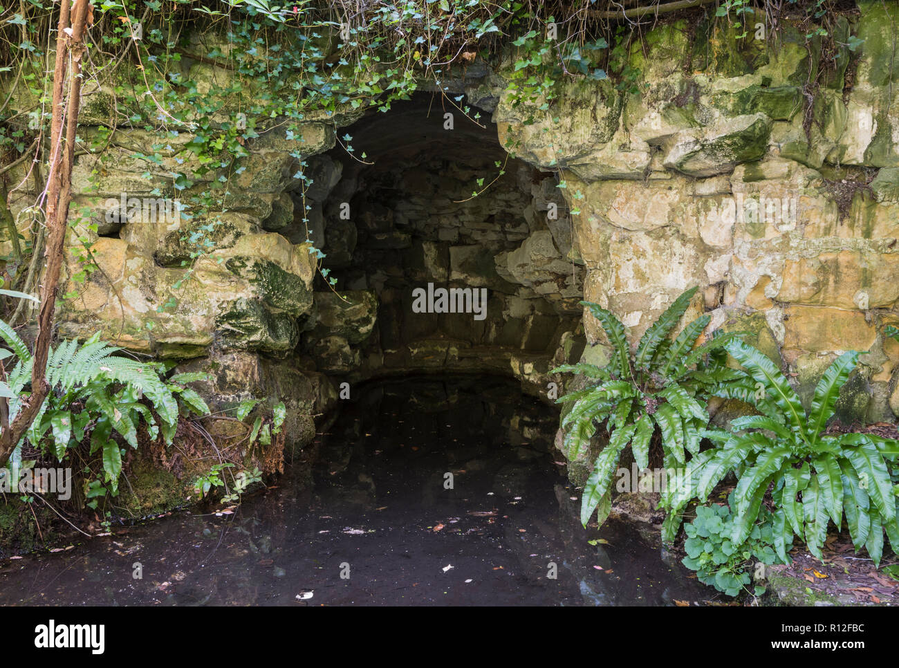 Il Highdown fornace di calce, un mattone-forno rivestito presso la grotta pond, guardando come una piccola grotta, a Highdown giardini, West Sussex, in Inghilterra, Regno Unito. Foto Stock