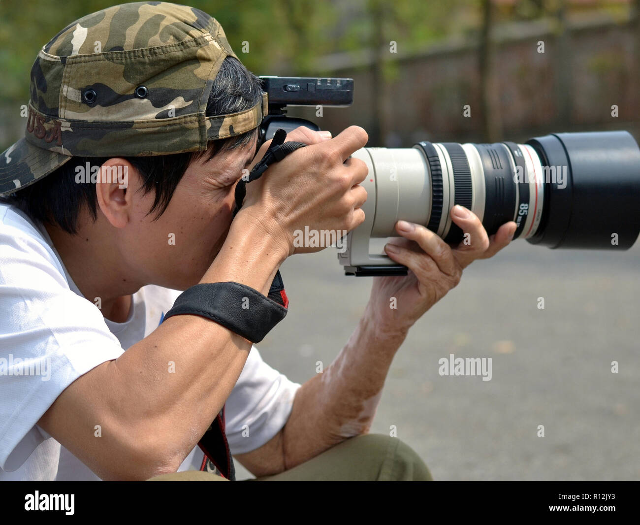 Il vietnamita fotografo professionista scatta una fotografia con la sua Canon EOS 6D fotocamera reflex digitale. Foto Stock