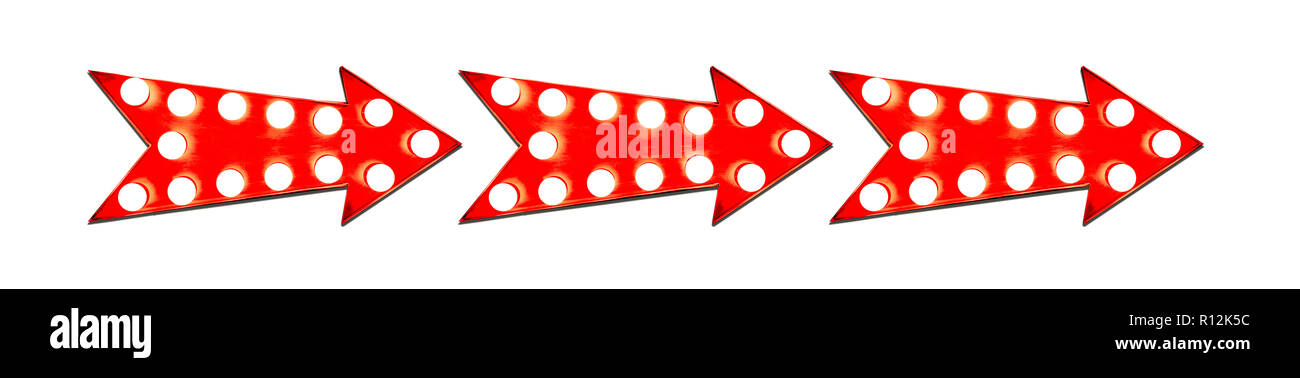 Tre in linea rosso a forma di freccia vintage illuminate metallico direzione display segno con incandescente lampadine luce e ombra e isolato tagliare o Foto Stock