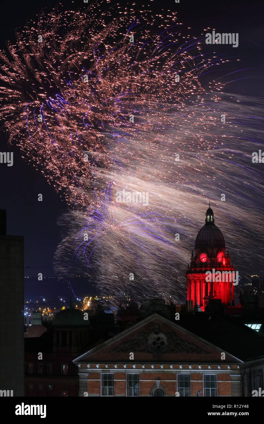 Leeds 8 novembre 2018. Fuochi d'artificio dal Leeds Interruttore Luci su illuminano il cielo notturno dietro Leeds Town Hall illuminato di rosso per il Leeds International Film Festival. Foto Stock