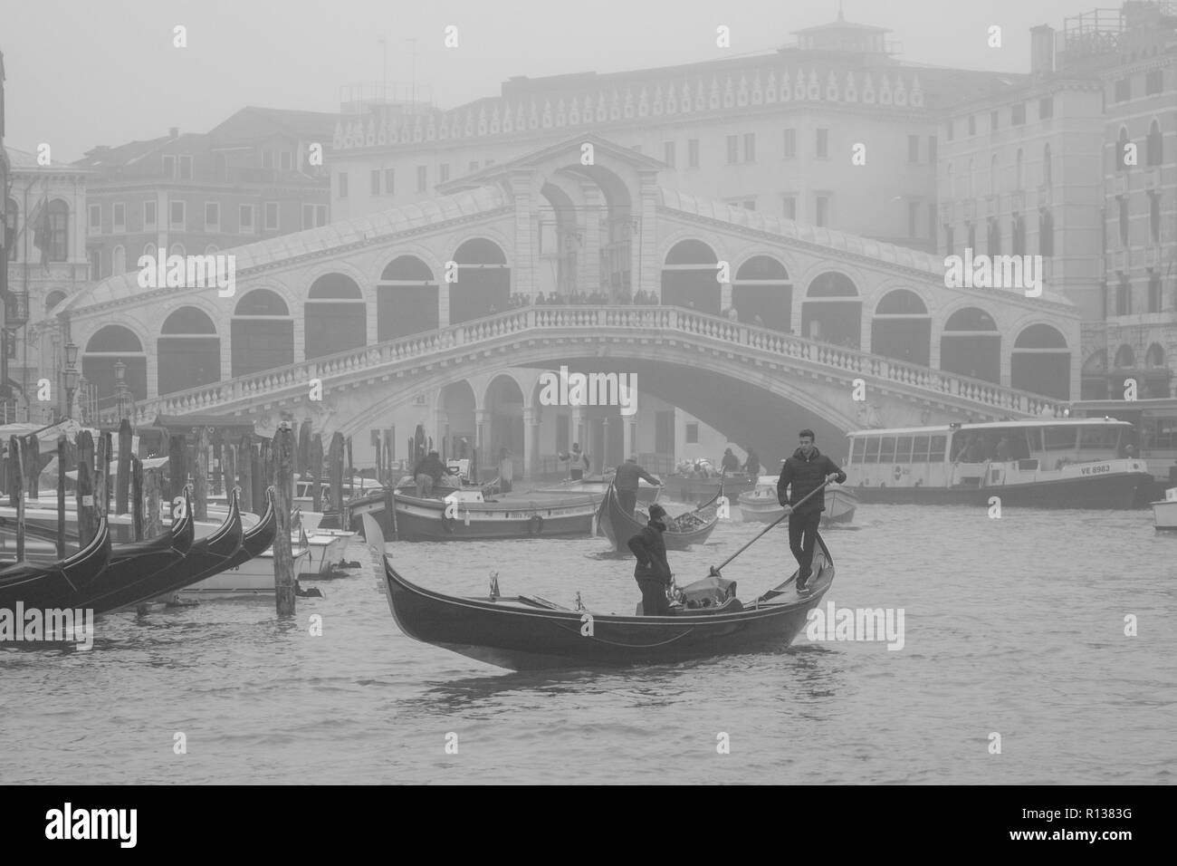 Venezia, Italia. 09 Novembre, 2018. [Questa immagine è stata convertita in bianco e nero] un gondoliere vele sul Canal Grande vicino al Ponte di Rialto mentre la città è immersa in una nebbia morbida su Novembre 09, 2018 a Venezia, Italia. Venezia si è svegliato con i primati di nebbia morbida, chiamati in dialetto veneziano 'Caligo'. © Simone Padovani / risveglio / Alamy Live News Foto Stock