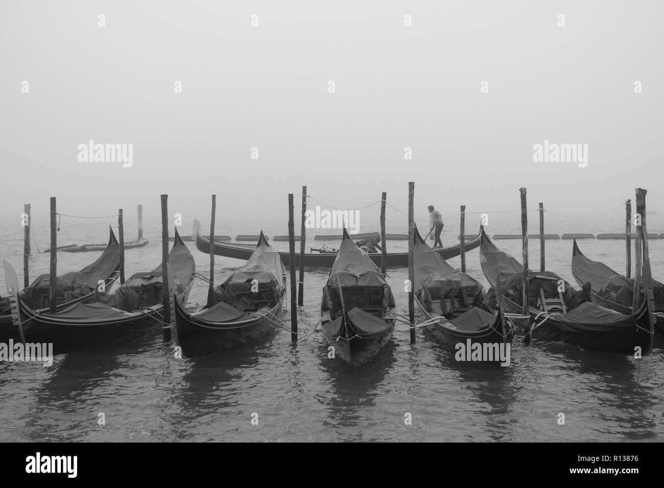 Venezia, Italia. 09 Novembre, 2018. [Questa immagine è stata convertita in bianco e nero] un gondoliere vele di fronte a Piazza San Marco, mentre la città è immersa in una nebbia morbida su Novembre 09, 2018 a Venezia, Italia. Venezia si è svegliato con i primati di nebbia morbida, chiamati in dialetto veneziano 'Caligo'. © Simone Padovani / risveglio / Alamy Live News Foto Stock