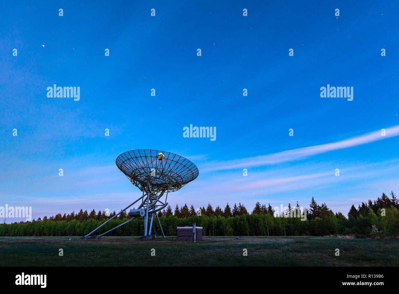 Il Westerbork Synthesis Radio Telescope (WSRT) durante il tramonto, con una luce di cielo nuvoloso e stelle un po' visibile. Apertura di un interferometro di sintesi Foto Stock
